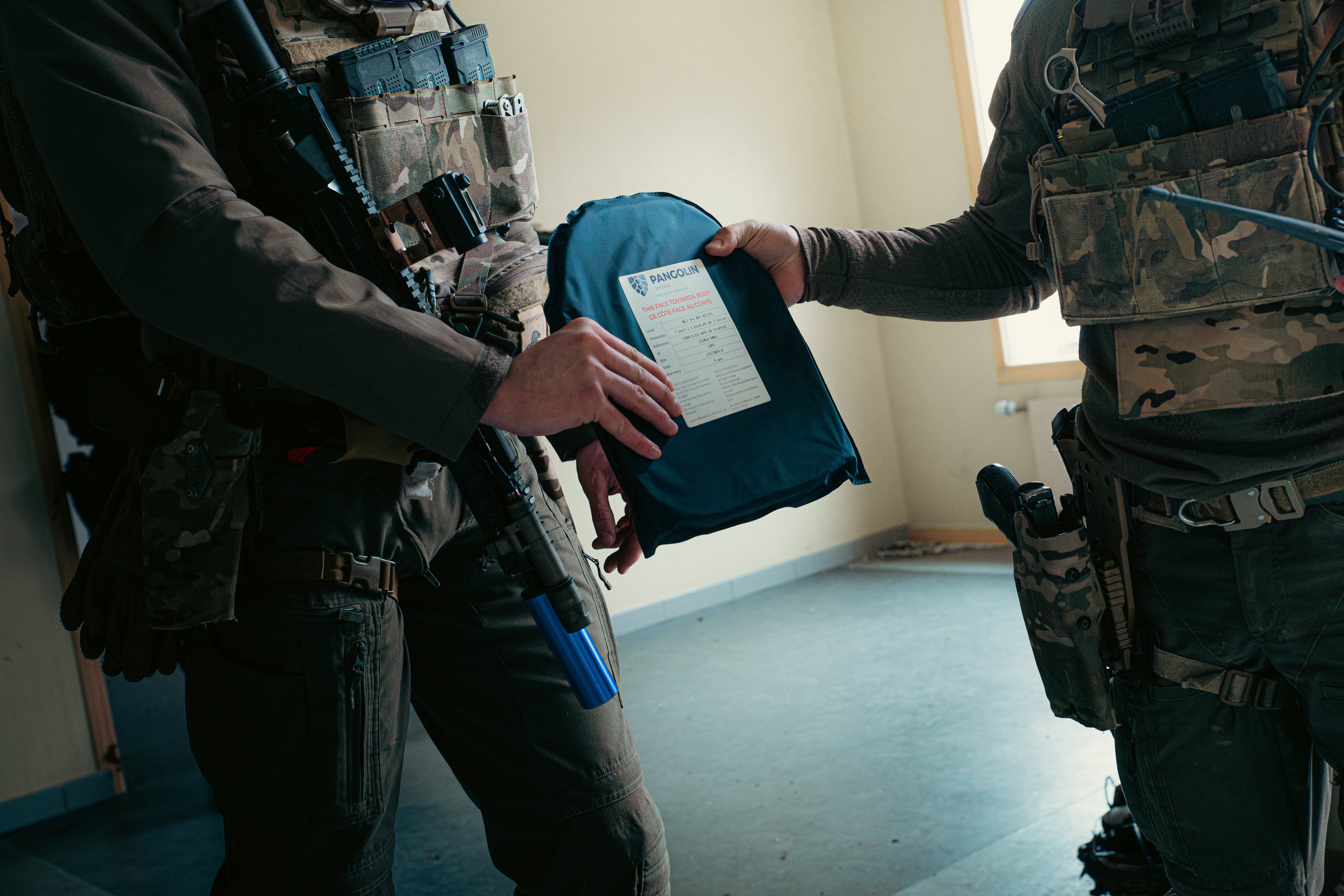 Photo d'une plaque balistique entre 2 militaires